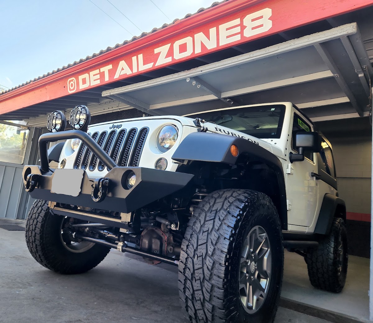 Freshly detailed Jeep in front of the Detail Zone shop